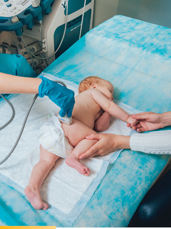 A baby on his side getting tested with a portable  ultrasound